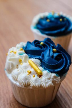 Lüks ve zarif kekler, beyaz kremalı ve lacivert üzerine altın serpiştirilmiş. Tatlı ve kremalı bir tadı var..