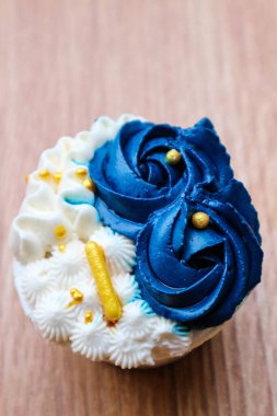 Lüks ve zarif kekler, beyaz kremalı ve lacivert üzerine altın serpiştirilmiş. Tatlı ve kremalı bir tadı var..