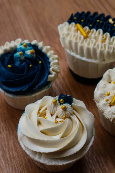 Lüks ve zarif kekler, beyaz kremalı ve lacivert üzerine altın serpiştirilmiş. Tatlı ve kremalı bir tadı var..