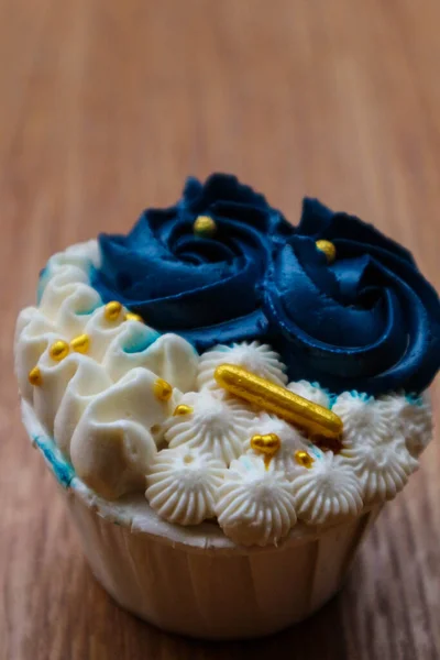 Luxurious and elegant cupcakes, with white cream and navy blue with gold sprinkles. It has a sweet and creamy taste.