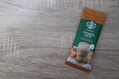 Bekasi, Indonesia on July 2022. Copy space starbucks caramel latte sachet, Starbucks premium instant coffee sachet original from Turkey. We can enjoy Starbucks coffee easily from home.