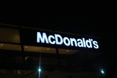 West Java, Indonesia on July 2022. Glowing McDonalds restaurant sign against night sky. Logo of Mcd Drive Thru. McDonald's is the world's largest restaurant chain by revenue,