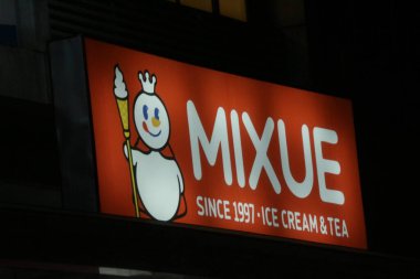 Bekasi, Indonesia on July 2022. Glowing MIXUE restaurant sign against night sky. Mixue is a popular cold beverage ice cream shop. It is originally from China and recently opens in Indonesia.