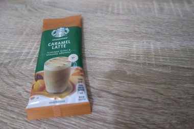 Bekasi, Indonesia on July 2022. Copy space starbucks caramel latte sachet, Starbucks premium instant coffee sachet original from Turkey. We can enjoy Starbucks coffee easily from home.