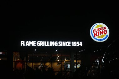 Bekasi, Indonesia in July 2022. Burger King logo shining brightly at night against the dark night sky. Burger King is a restaurant that sells fast food, especially burgers which are very famous in Indonesia