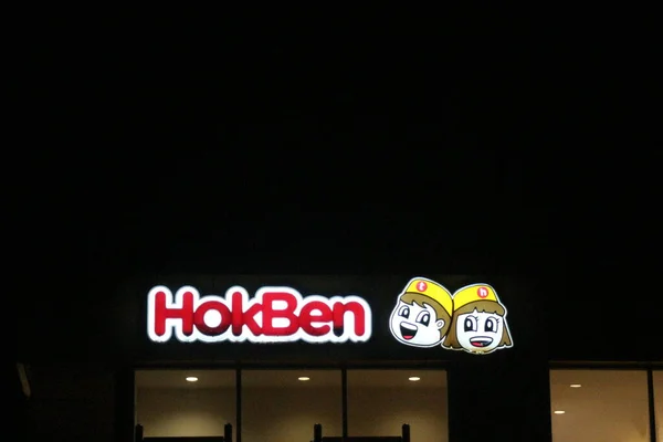 Bekasi, Indonesia in July 2022. Hokben or Hoka Hoka bento logo shining brightly at night against the dark night sky. Hokben is a very famous bento restaurant in Indonesia