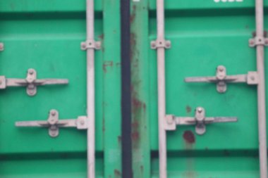 Back view of the container in green. You see a locked door. Door locks and handles are made of steel with a silver color. Galvanized steel.