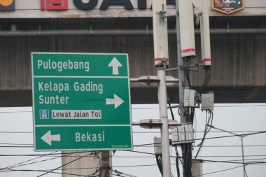 Bekasi, Indonesia on July 2022. Signs for directions to Pulo Gebang, Kelapa Gading, Sunter and Bekasi. This signpost is green with white writing and lines.