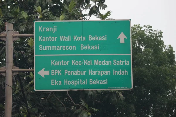Bekasi, Indonesia on July 2022. Road signs to Kranji, Bekasi Mayor's Office, Summarecon Bekasi, Medan Satria sub-district or urban village office, BPK Penabur Harapan Indah and Eka Hospital Bekasi. This signpost is green with white writing and lines