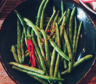 Saut the garlic chickpeas. The young chickpeas are not cut into pieces so that the texture remains crunchy. Saute with onions and chilies so it has a delicious and slightly spicy taste.