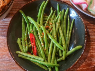Saut the garlic chickpeas. The young chickpeas are not cut into pieces so that the texture remains crunchy. Saute with onions and chilies so it has a delicious and slightly spicy taste.