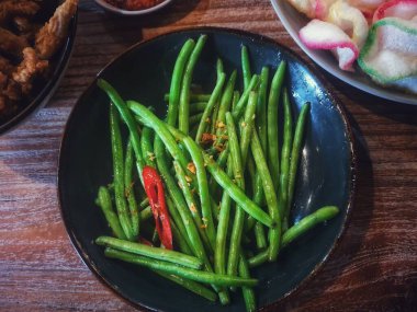 Saut the garlic chickpeas. The young chickpeas are not cut into pieces so that the texture remains crunchy. Saute with onions and chilies so it has a delicious and slightly spicy taste.