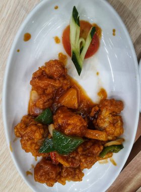 Sweet and sour chicken is fried chicken pieces with flour doused with a thick red-brown sweet and sour sauce. The original sweet and sour sauce recipe only consists of water, vinegar, tomato sauce, chili sauce, lemon juice, garlic, onions and starch 