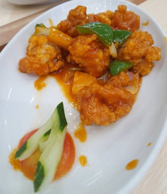 Sweet and sour chicken is fried chicken pieces with flour doused with a thick red-brown sweet and sour sauce. The original sweet and sour sauce recipe only consists of water, vinegar, tomato sauce, chili sauce, lemon juice, garlic, onions and starch 
