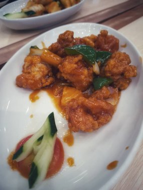 Sweet and sour chicken is fried chicken pieces with flour doused with a thick red-brown sweet and sour sauce. The original sweet and sour sauce recipe only consists of water, vinegar, tomato sauce, chili sauce, lemon juice, garlic, onions and starch 