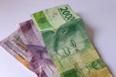 Isolated white photo of three rupiah banknotes. This money consisted of two ten thousand bills and one twenty thousand bill.