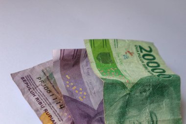Isolated white photo of three rupiah banknotes. This money consisted of two ten thousand bills and one twenty thousand bill.