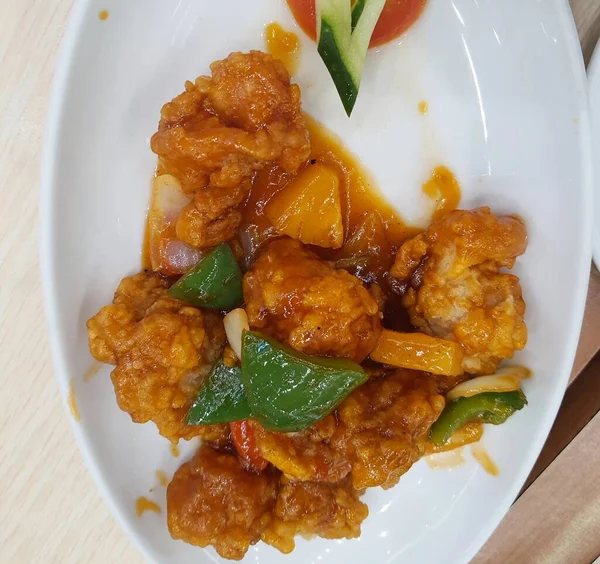 Sweet and sour chicken is fried chicken pieces with flour doused with a thick red-brown sweet and sour sauce. The original sweet and sour sauce recipe only consists of water, vinegar, tomato sauce, chili sauce, lemon juice, garlic, onions and starch