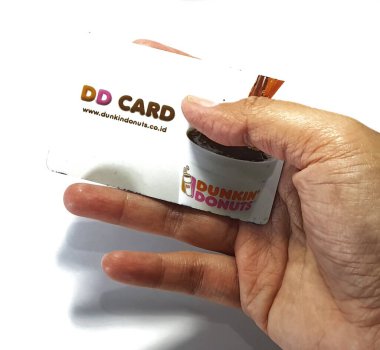West Java, Indonesia on July 2022. Isolated photo of a hand holding a loyalty card, DD Card. With this card, every time you make a transaction at Dunkin Donuts, you will get points that can be exchanged for shopping vouchers.