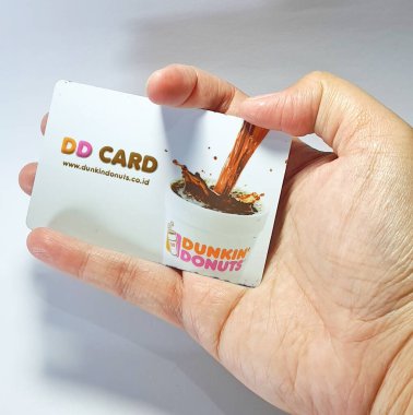 West Java, Indonesia on July 2022. Isolated photo of a hand holding a loyalty card, DD Card. With this card, every time you make a transaction at Dunkin Donuts, you will get points that can be exchanged for shopping vouchers.