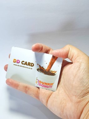 West Java, Indonesia on July 2022. Isolated photo of a hand holding a loyalty card, DD Card. With this card, every time you make a transaction at Dunkin Donuts, you will get points that can be exchanged for shopping vouchers.