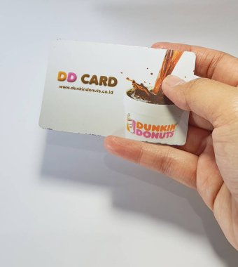 West Java, Indonesia on July 2022. Isolated photo of a hand holding a loyalty card, DD Card. With this card, every time you make a transaction at Dunkin Donuts, you will get points that can be exchanged for shopping vouchers.
