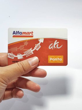 West Java, Indonesia on July 2022. Isolated photo of a hand holding a loyalty card, Alfa Gift Card. With this card, every time you make a transaction at Alfamart and Alfamidi stores. You will get points that can be exchanged for shopping vouchers.