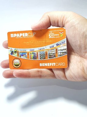 West Java, Indonesia on July 2022. Isolated photo of a hand holding a loyalty card, Benefit Card Paperclip. With this card, every time you make a transaction at a Paperclip shop, you will get points that can be exchanged for shopping vouchers.