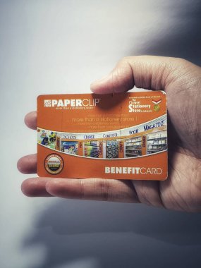 West Java, Indonesia on July 2022. Isolated photo of a hand holding a loyalty card, Benefit Card Paperclip. With this card, every time you make a transaction at a Paperclip shop, you will get points that can be exchanged for shopping vouchers.