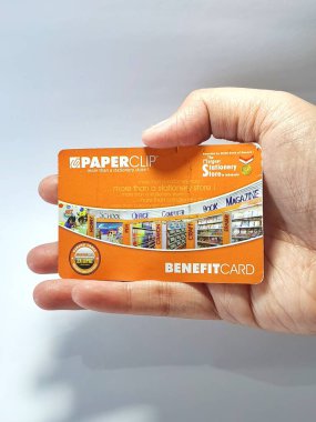 West Java, Indonesia on July 2022. Isolated photo of a hand holding a loyalty card, Benefit Card Paperclip. With this card, every time you make a transaction at a Paperclip shop, you will get points that can be exchanged for shopping vouchers.