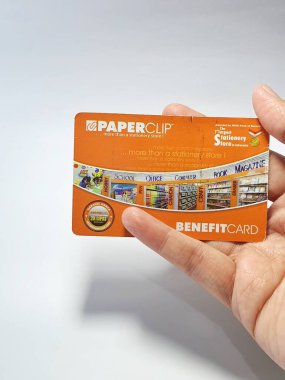 West Java, Indonesia on July 2022. Isolated photo of a hand holding a loyalty card, Benefit Card Paperclip. With this card, every time you make a transaction at a Paperclip shop, you will get points that can be exchanged for shopping vouchers.