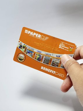 West Java, Indonesia on July 2022. Isolated photo of a hand holding a loyalty card, Benefit Card Paperclip. With this card, every time you make a transaction at a Paperclip shop, you will get points that can be exchanged for shopping vouchers.