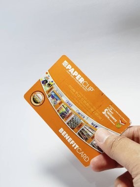West Java, Indonesia on July 2022. Isolated photo of a hand holding a loyalty card, Benefit Card Paperclip. With this card, every time you make a transaction at a Paperclip shop, you will get points that can be exchanged for shopping vouchers.