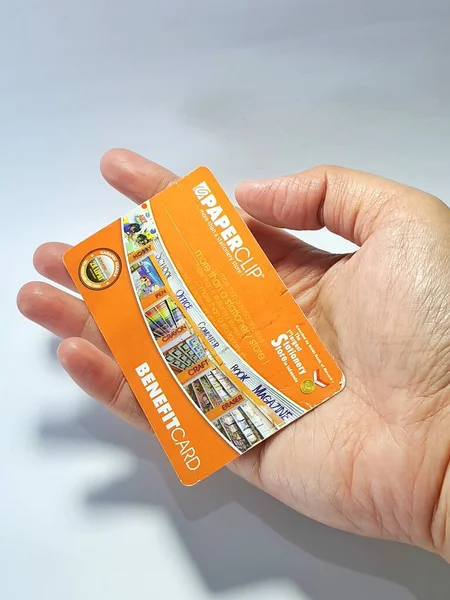 West Java, Indonesia on July 2022. Isolated photo of a hand holding a loyalty card, Benefit Card Paperclip. With this card, every time you make a transaction at a Paperclip shop, you will get points that can be exchanged for shopping vouchers.