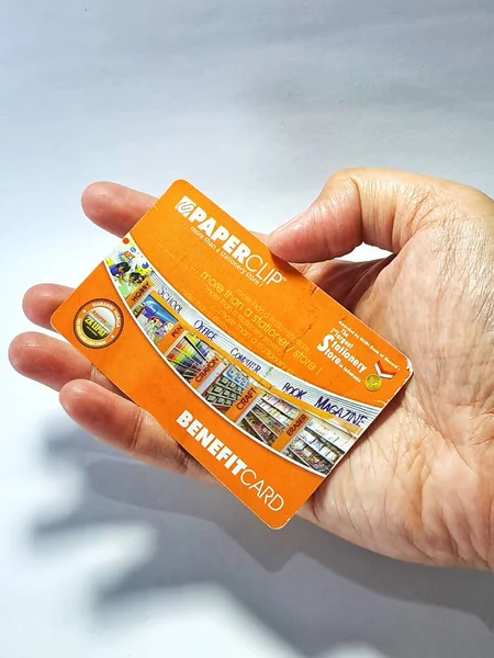 West Java, Indonesia on July 2022. Isolated photo of a hand holding a loyalty card, Benefit Card Paperclip. With this card, every time you make a transaction at a Paperclip shop, you will get points that can be exchanged for shopping vouchers.