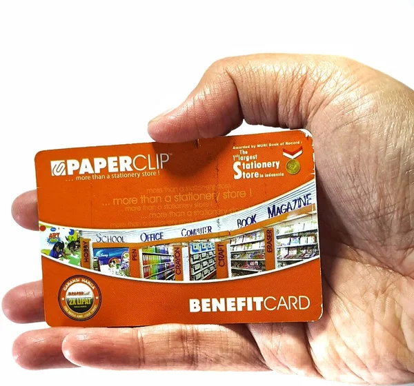 West Java, Indonesia on July 2022. Isolated photo of a hand holding a loyalty card, Benefit Card Paperclip. With this card, every time you make a transaction at a Paperclip shop, you will get points that can be exchanged for shopping vouchers.