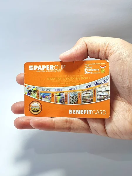 West Java, Indonesia on July 2022. Isolated photo of a hand holding a loyalty card, Benefit Card Paperclip. With this card, every time you make a transaction at a Paperclip shop, you will get points that can be exchanged for shopping vouchers.
