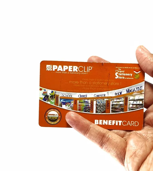 West Java, Indonesia on July 2022. Isolated photo of a hand holding a loyalty card, Benefit Card Paperclip. With this card, every time you make a transaction at a Paperclip shop, you will get points that can be exchanged for shopping vouchers.