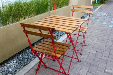 The exterior of a restaurant, which uses chinese style furniture. Red wooden chairs combined with a wooden table. This restaurant is perfect for breakfast and lunch breaks.