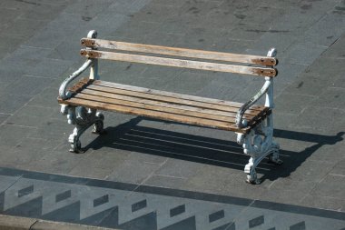 A wooden chair on the side of the road, no one sits on it.