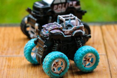 Mini monster truck toy with big blue wheels. Monster truck is a special off-road vehicle with heavy-duty suspension, four-wheel steering,