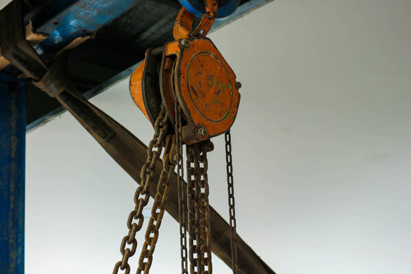 Rusty industrial chain hoist for reduce working load and lifting heavy object, mechanical hoist, gear hoist for one man operation with heavy weight mold and die.