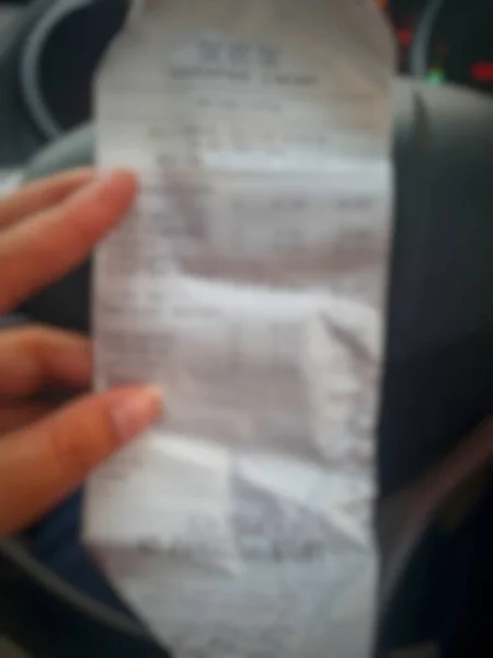 Defocused Blurred Photo Hand Holding Shopping Receipt Which Displays List — Stock fotografie