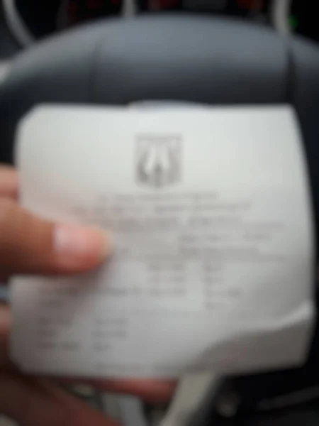 Defocused Blurred Photo Hand Holding Shopping Receipt Which Displays List — Stockfoto