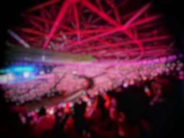 Defocused blurred photo of the atmosphere of blackpink's concert in Jakarta, Born in Pink. The ambience of pink lights dominated, very crowded, exciting and fun.