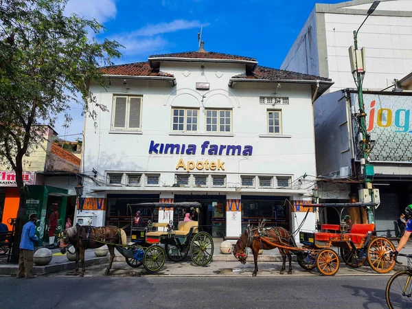 2022年3月にインドネシアのジョグジャカルタ マリオボロ通りにあるキミア ファーマの薬局の建物はオランダの古い建物が保存されている 建物の前には丹東があり 乗客を待っている運転手がいます — ストック写真