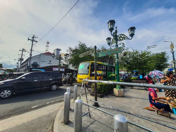 2022年7月にインドネシアのジョグジャカルタ マリオボロ通りを横断するトランス ジョグジャバス バスはトランスジョグジャ Bpd Diyのロゴと色の真鍮に緑色で バスの後ろにKm 0ジョグジャカルタ記念碑の写真があります — ストック写真
