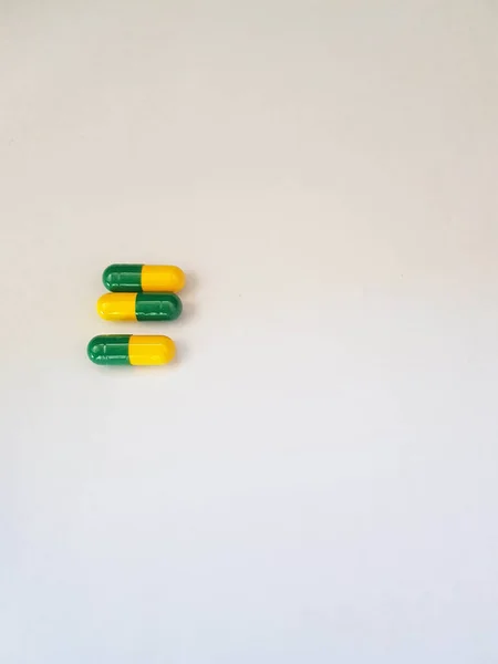 Foto Branca Isolada Três Cápsulas Medicamento Cápsulas São Verdes Amarelas — Fotografia de Stock