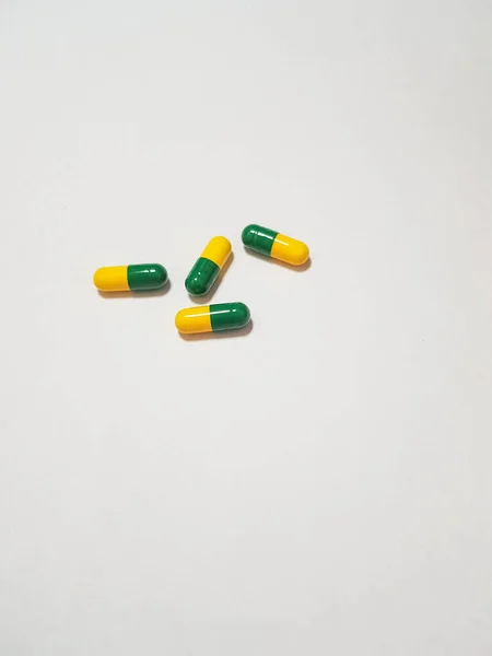 Foto Branca Isolada Quatro Cápsulas Medicamento Cápsulas São Verdes Amarelas — Fotografia de Stock