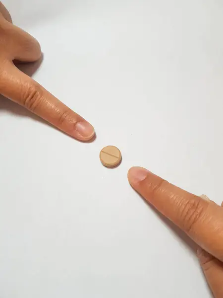 两张食指指向棕色药物片的孤立的白色照片 一个例子与药物研究有关 药物研究是对病人合适的药物 — 图库照片